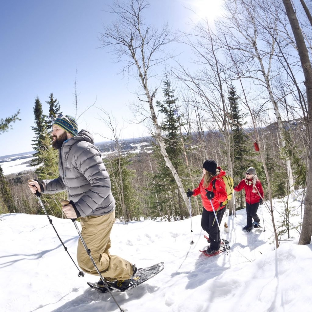 Les collines Kekeko, pour le plein air en hiver, sont un coup de coeur de Rouyn-Noranda. Ici, trois personne en raquette par une journée ensoleillée d'hiver. 